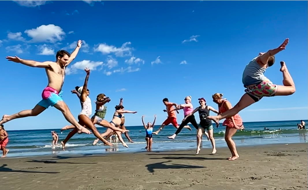 Gymnastics performing leaps during the beach trip at the adult gymnastics camp 2023. leaps adult gymnastics camp 2023