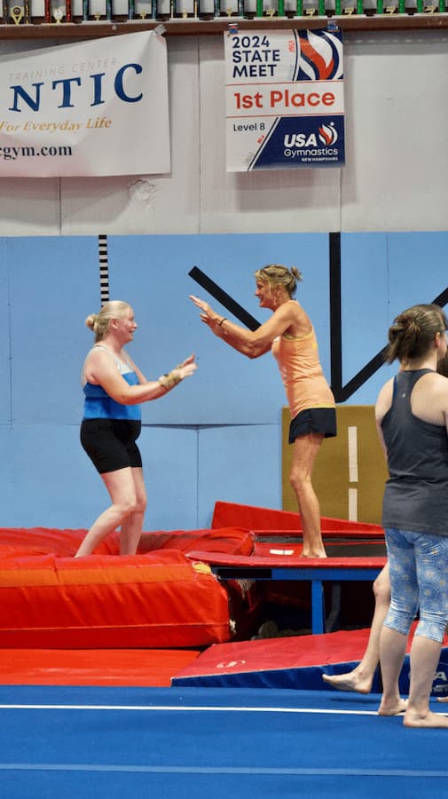 coach liz congratulating an adult athlete at the gymnastics camp