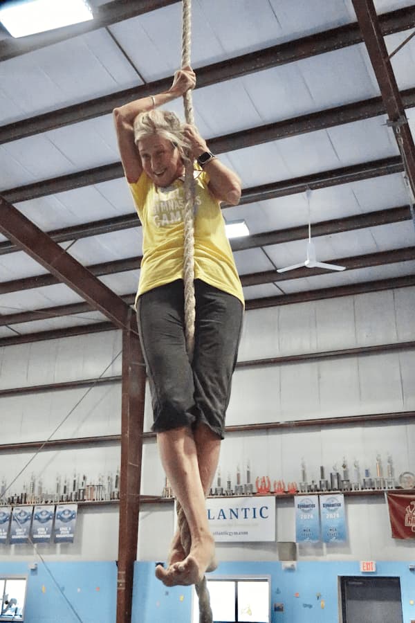 an athlete climbing the rope at the adult gymnastics camp